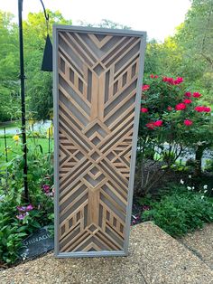 a decorative wooden panel in the middle of a garden