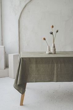 two vases with flowers are sitting on a table