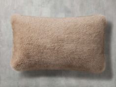 a beige pillow on a gray wall