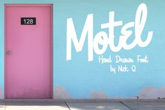 a pink door is in front of a blue wall with the word motel painted on it