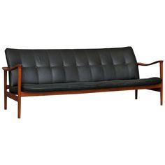 a black leather futon sofa with wooden frame