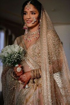 a woman in a bridal gown holding a bouquet of flowers and jewelry on her wedding day