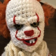 a crocheted clown doll with red nose and mouth