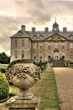 a large stone building sitting on top of a lush green field