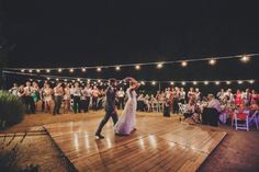 a bride and groom dancing on the dance floor at their wedding reception in front of an audience