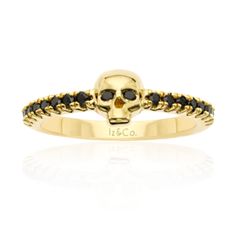 a gold skull ring with black stones on the sides and an inscription that reads, i co