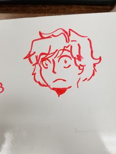 a drawing of a woman's face on a piece of paper with red ink