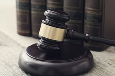 a wooden judge's gavel sitting on top of a table next to books