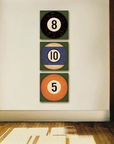 three pool balls sitting on top of each other in front of a wall with numbers