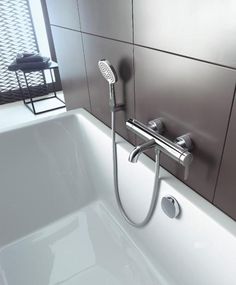 a bathtub with thermostaer and hand held shower head