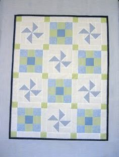 a blue and green quilt with an arrow design on the front, along with two different colored blocks