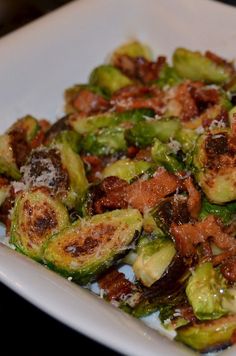 brussel sprouts with bacon and parmesan cheese on a white plate