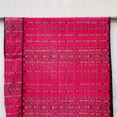 a pink and black piece of cloth hanging on a wall