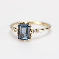 a blue and white diamond ring on a white surface