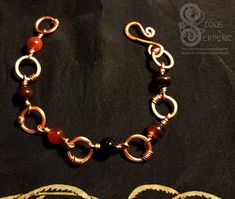 This copper and Red Agate bracelet is a  great addition to  your everyday!    Handmade with copper this chain bracelet boasts 6 beautiful Red Agate spheres and 6 handmade  copper `circle links. This bracelet's unique design and beautiful red agate beads are sure to add some fun to ones outfit. Red agate is known for promoting strength, courage, success, and luck. One of a kind. Handmade in COLORADO, USA. Lead and nickel free. Spiritual Copper Bracelets With Round Beads, Handmade Carnelian Bracelet, Diy Chain, Outfit Red, Wire Wrapping Crystals, Colorado Usa, Copper Red, Agate Bracelet, Red Agate