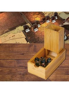 a wooden box with dices in it sitting on a table next to a board game