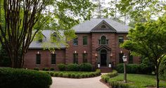 a large brick house surrounded by trees and bushes