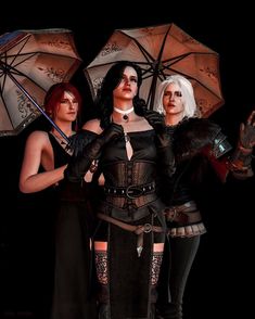 three women dressed in gothic clothing holding umbrellas and posing for the camera on a black background