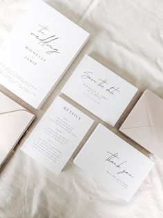 wedding stationery and envelopes laid out on a bed