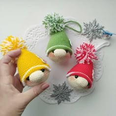 two small crocheted gnomes on a doily with snowflakes around them