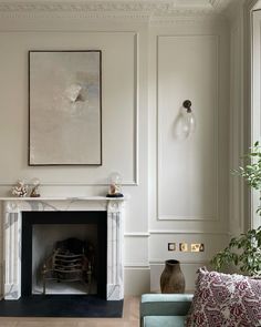 a living room filled with furniture and a painting on the wall over a fire place