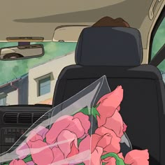 a car filled with pink flowers sitting in the passenger seat next to a person holding an umbrella