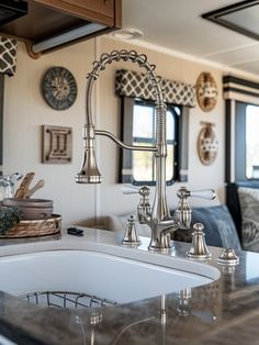 a kitchen sink sitting under a faucet next to a counter top in front of a window