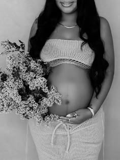 a pregnant woman holding flowers in her belly