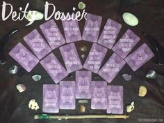 a table topped with lots of purple cards next to some rocks and other things on top of it