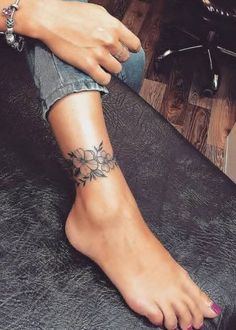 a woman's foot with a tattoo on her left arm and the bottom part of her leg