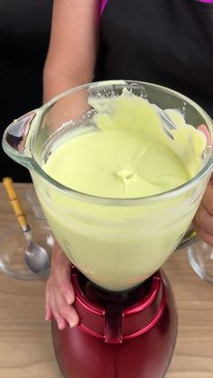 a person mixing something in a bowl on top of a blender