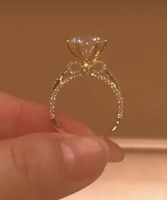 a person holding up a diamond ring in their hand