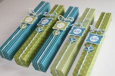 four green and blue gift boxes with tags on the top, tied in twine