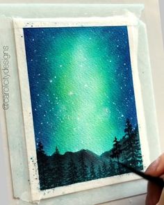 someone is painting an aurora bore in the night sky with green and blue hues