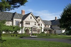 a large white house sitting on top of a lush green field