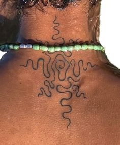 the back of a woman's neck with tattoos on it