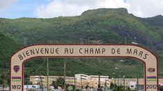 a sign that is on the side of a road in front of a mountain range