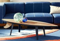 a living room with a blue couch and wooden coffee table in front of the couch