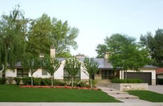 a white house with green grass and trees