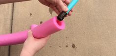 two children holding pink and blue toothbrushes in their hands on the cement ground