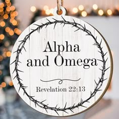 a wooden ornament hanging from a string with the words,'apha and omega revaletion 22 13