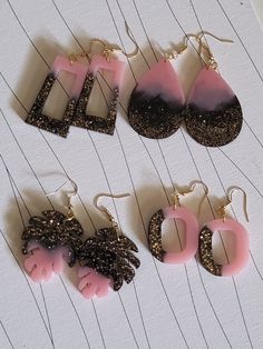 three pairs of earrings with pink and black designs