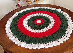 a crocheted table top with a red, white and green circle on it