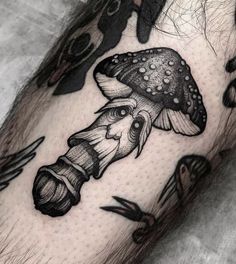 a man's leg with tattoos on it and a mushroom tattoo on the arm