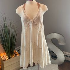 Intimately Free People Lace Off-White Dress Has A Deep V-Neck Cut With See Through Lace At The Top With The Bottom Lace Having An Underlay. Bralette Sold Separately. 70s Lace Dress, 70s Sun Dress, Feminine White V-neck Beach Dress, Flowy V-neck Boho Dress With Lace Trim, Flowy V-neck Sundress With Lace Trim, Summer Mini Dress With Lace Trim And V-neck, White V-neck Boho Summer Dress, Elegant White V-neck Boho Dress, Cream V-neck Sundress For Spring