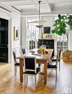 an elegant dining room with wood floors and white walls