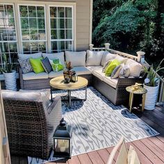 an outdoor living area with wicker furniture and potted plants