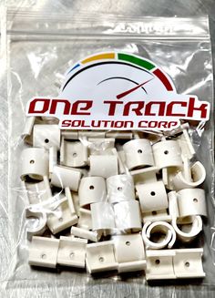 a bag of white plastic clips with one track logo on the front and two rows of them