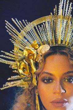 a close up of a woman wearing a gold headpiece