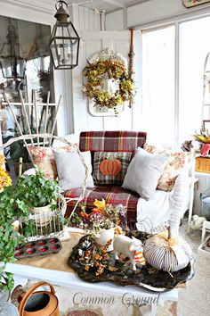 a living room filled with furniture and lots of fall decorations on top of the table